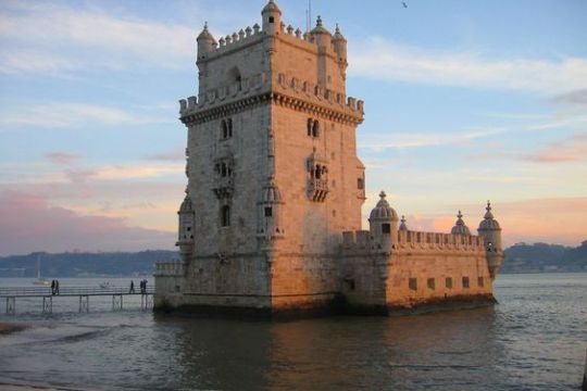 a castle with a clock at the top of Belém Tower