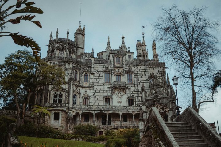 a large clock tower in front of Quinta da Regaleira