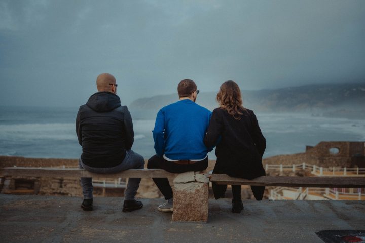 a person sitting on a bench in front of a body of water