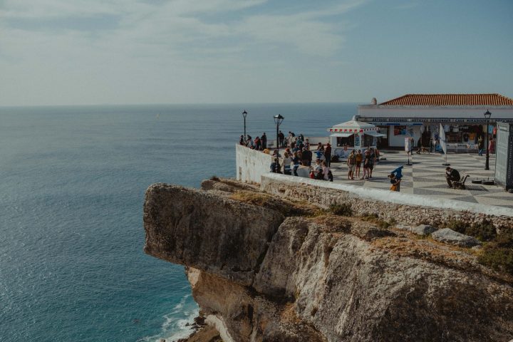 a group of people standing next to a body of water