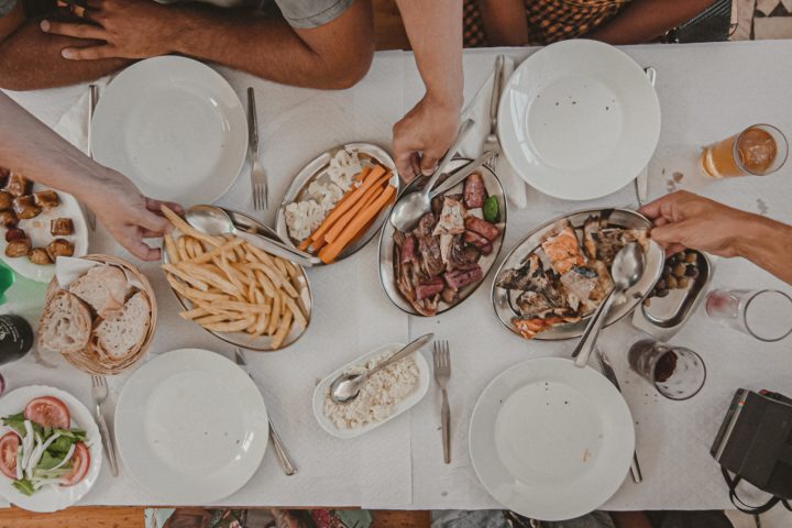 a group of people sitting at a table with a plate of food