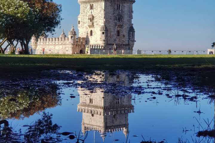 a castle with a clock tower next to a body of water