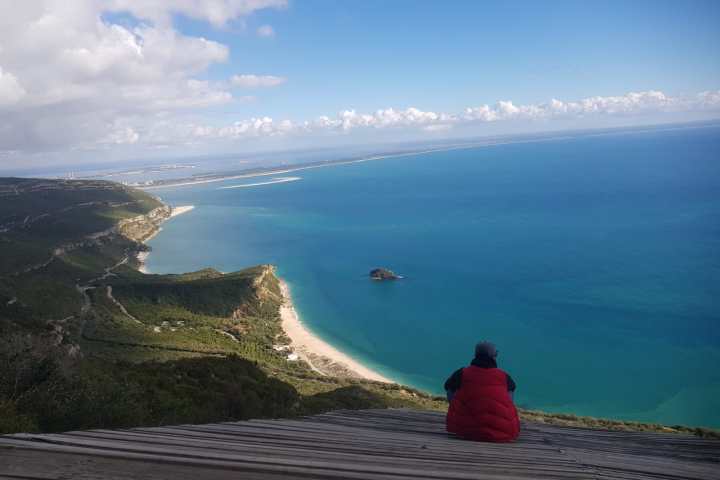 a man standing next to a body of water