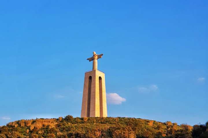 a large tall tower with a mountain in the background