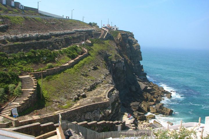 a close up of a hillside next to a body of water