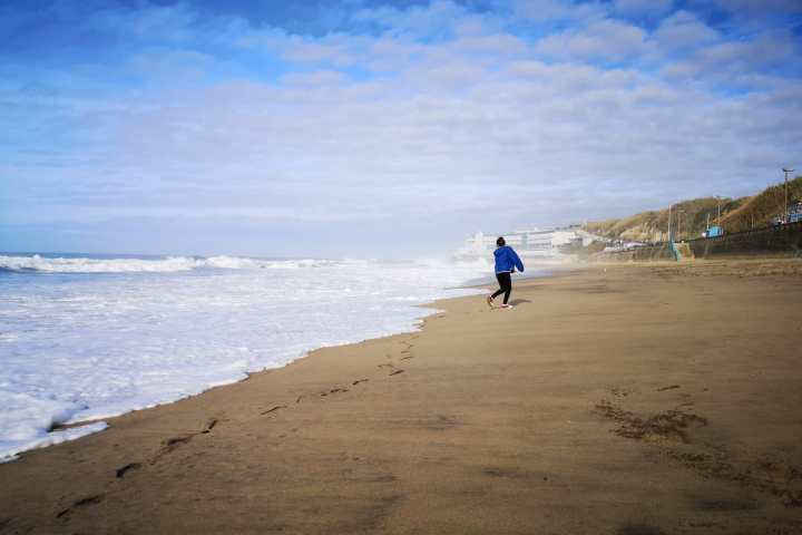 a man riding on top of a sandy beach