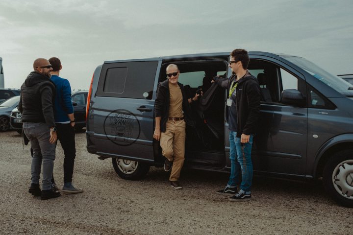 a group of people standing in front of a car