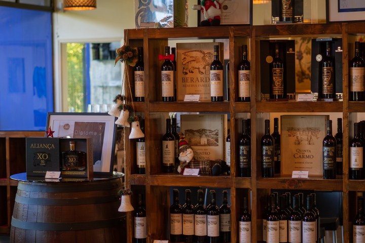 Wooden shelves displaying various wine bottles and boxes in a store setting.