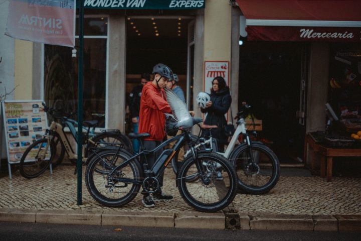 a person riding a bicycle in front of a store