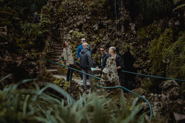 a group of people standing next to a wire fence